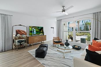 A living room with a couch and a table and a large window